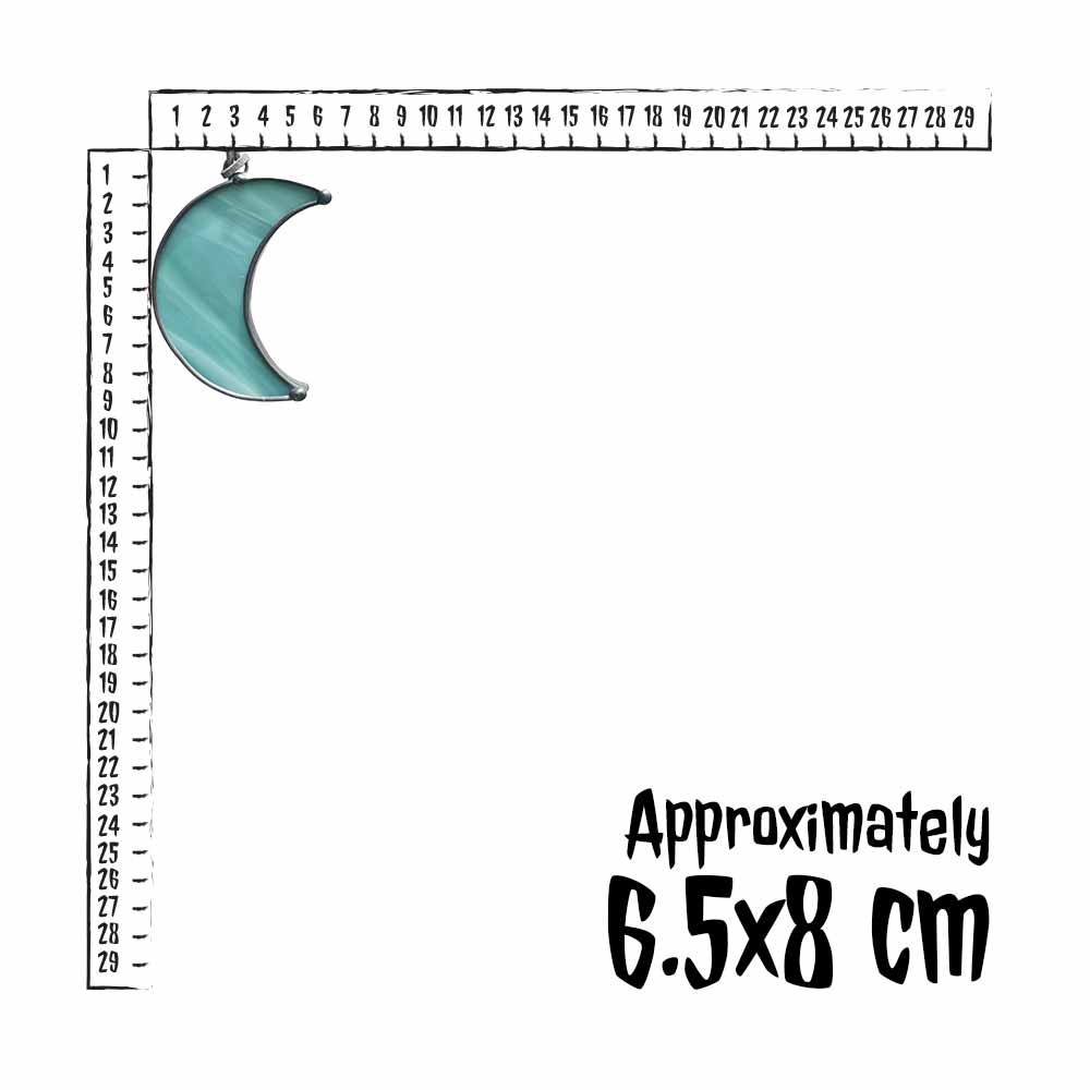 Teal stained glass crescent moon pendant next to a ruler for size reference.