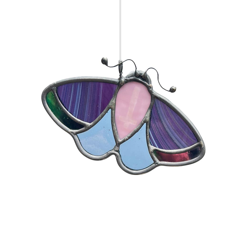 Mystical purple stained glass moth with engraved upside-down cross, artisan-made hanging decor piece for home.