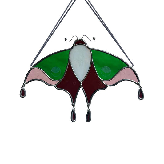 Stained glass moth decoration with green, pink, and white colors on a white background