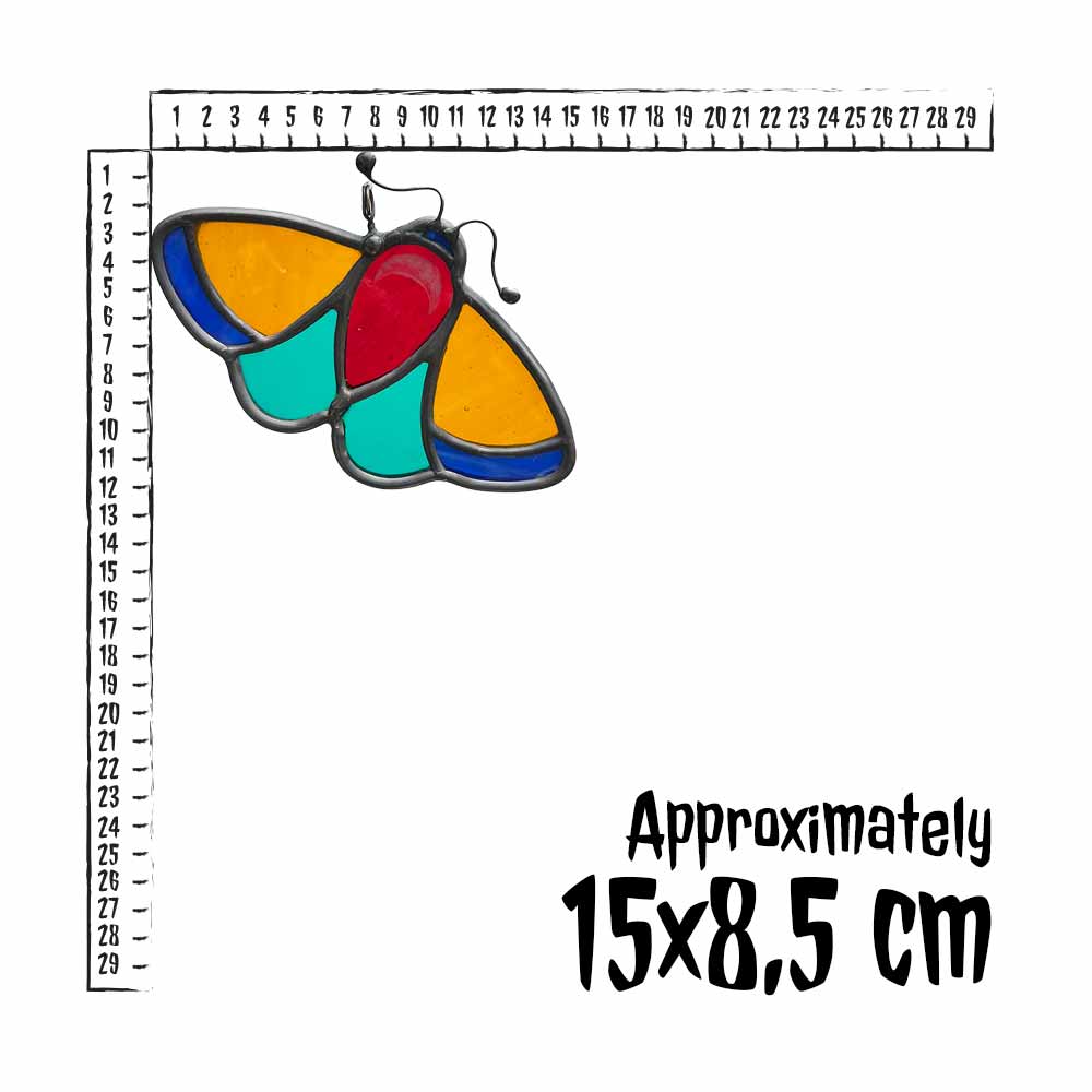 Coluorful stained glass moth with a ruler for scale on a white background