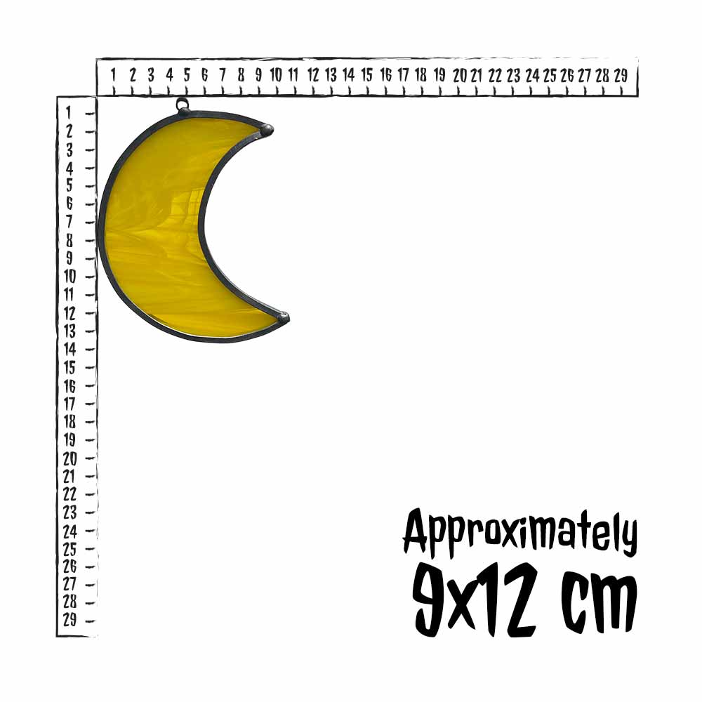 Yellow stained glass crescent moon with a ruler for scale on a white background