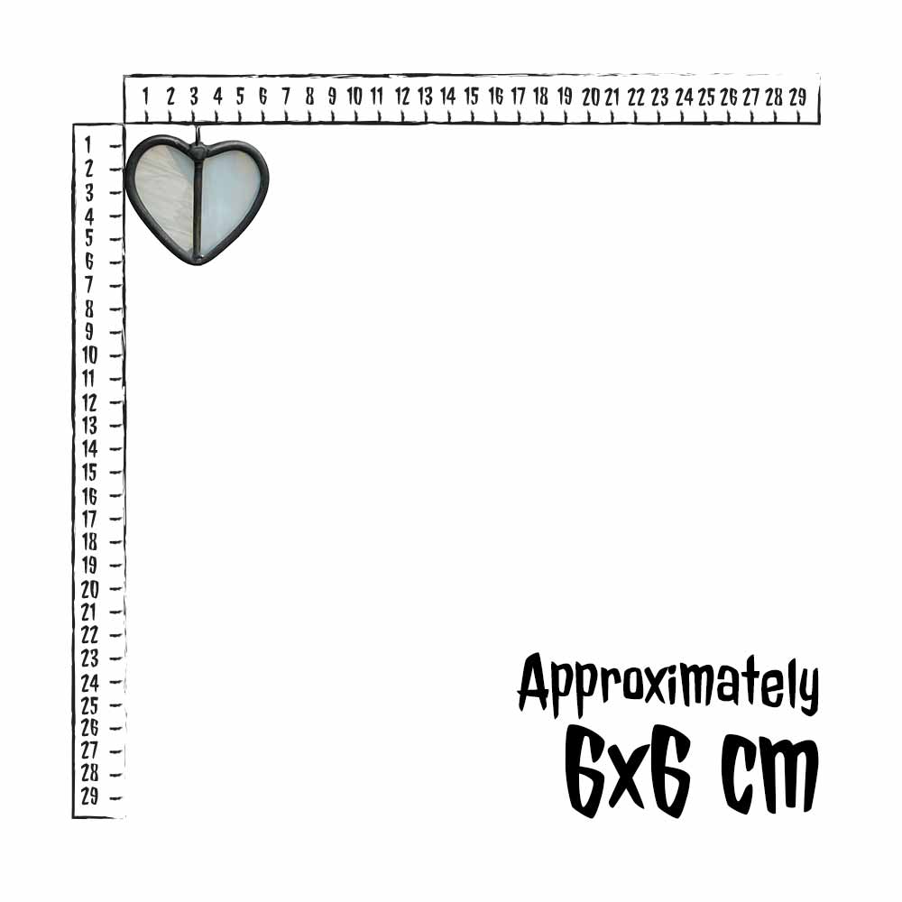 Small white  stained glass heart charm next to a ruler for scale, with text indicating size.